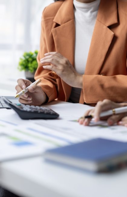 Businesswomen team working together on a new project, using a calculator to analyze a financial report